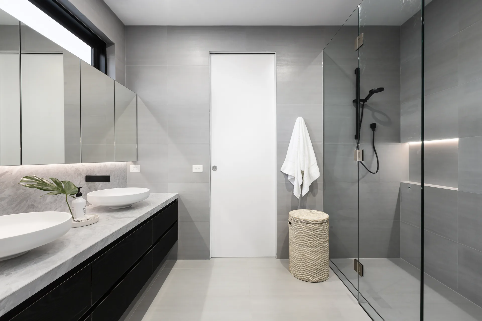 Baño pequeño reformado en Zaragoza con ducha de cristal y azulejo gris